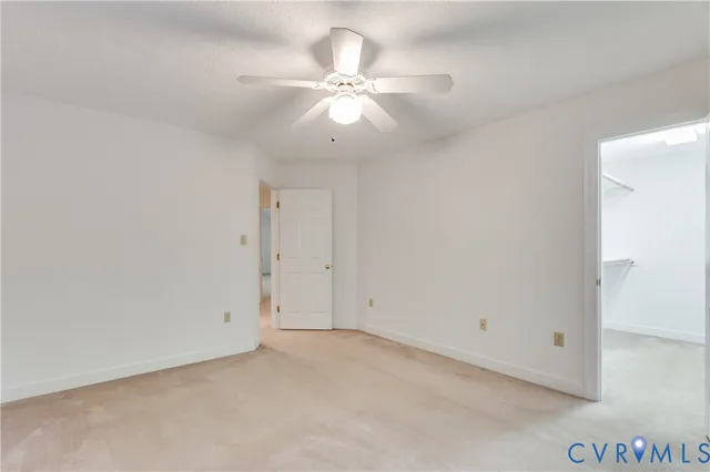 an empty room with a ceiling fan and a window