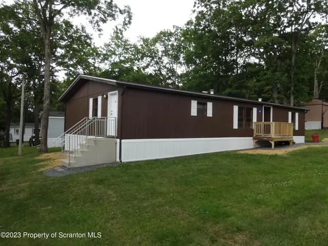a front view of a house with a yard and trees