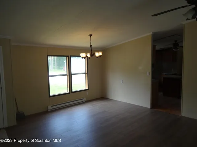 an empty room with windows and chandelier