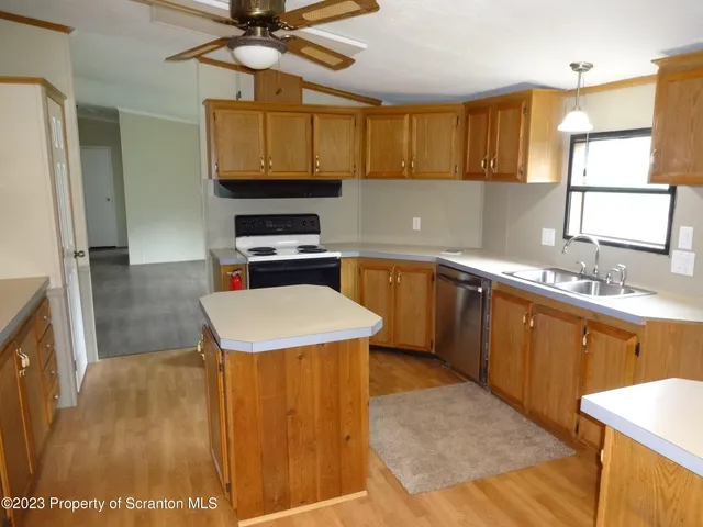 a kitchen with a sink a stove cabinets and stainless steel appliances