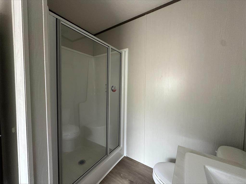 14 Liberty Road Crowley, TX 76036 - Photo 8 of 10 Bathroom featuring a shower with shower door, hardwood / wood-style floors, and toilet