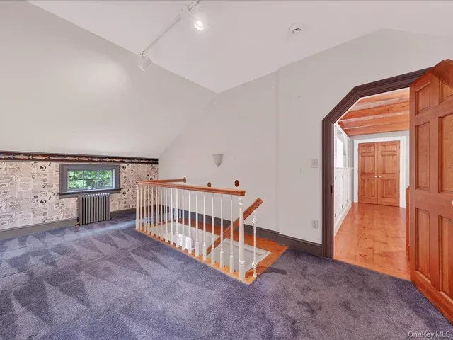 an empty room with windows and ceiling fan