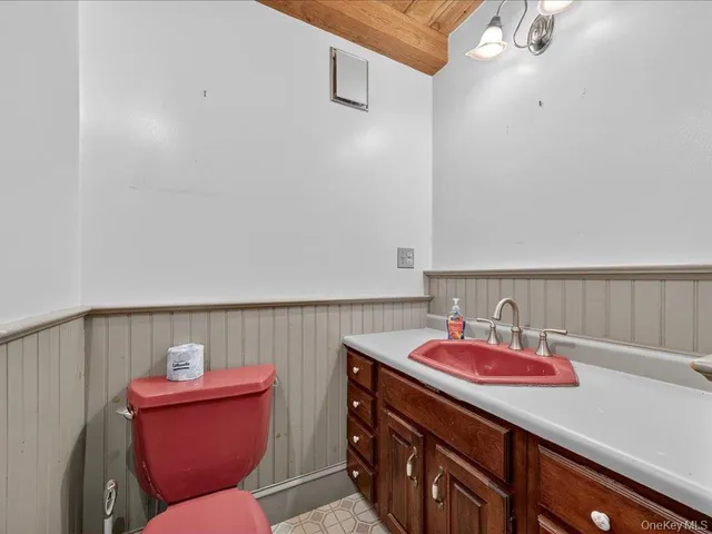 a bathroom with a sink mirror and toilet