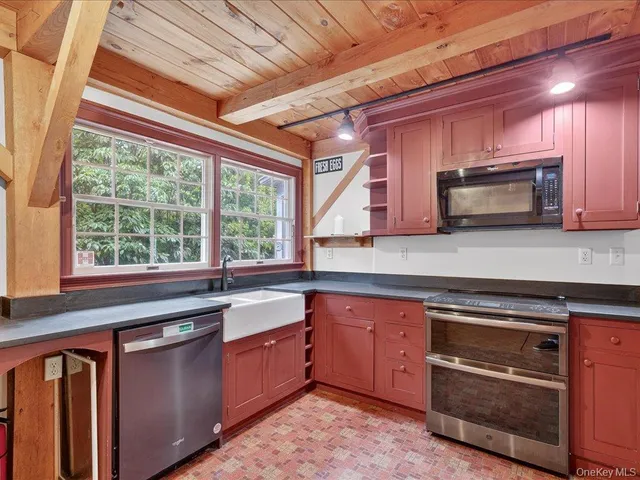 a kitchen with granite countertop wooden cabinets stainless steel appliances and a window
