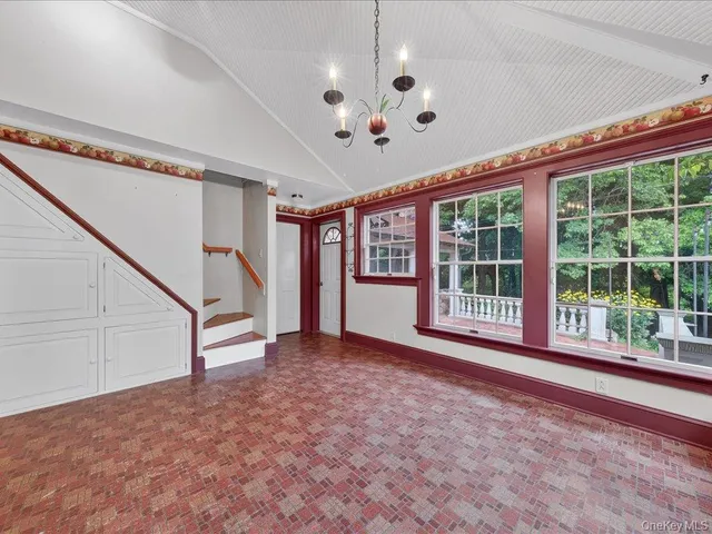a view of an empty room with a window and ceiling fan