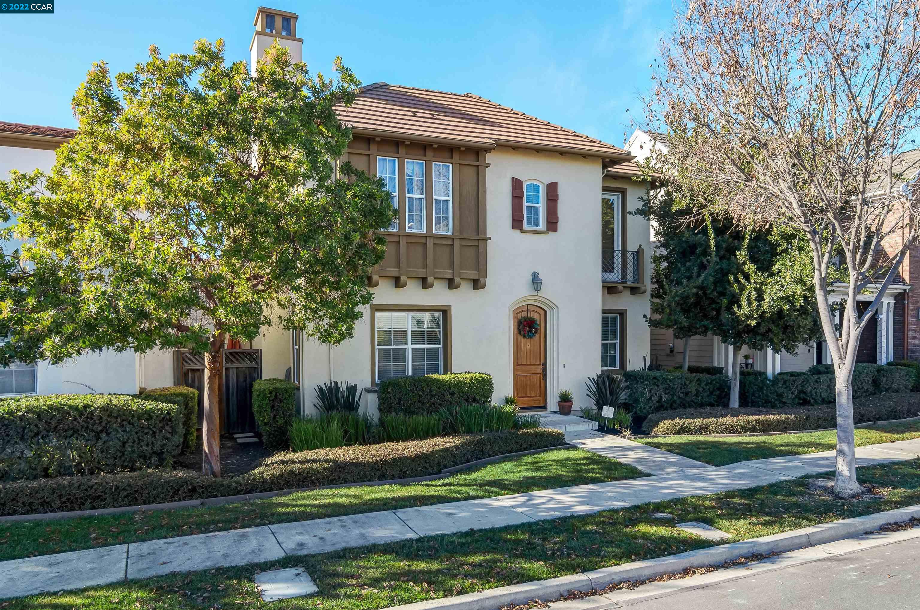 a view of a white house with a yard and large tree