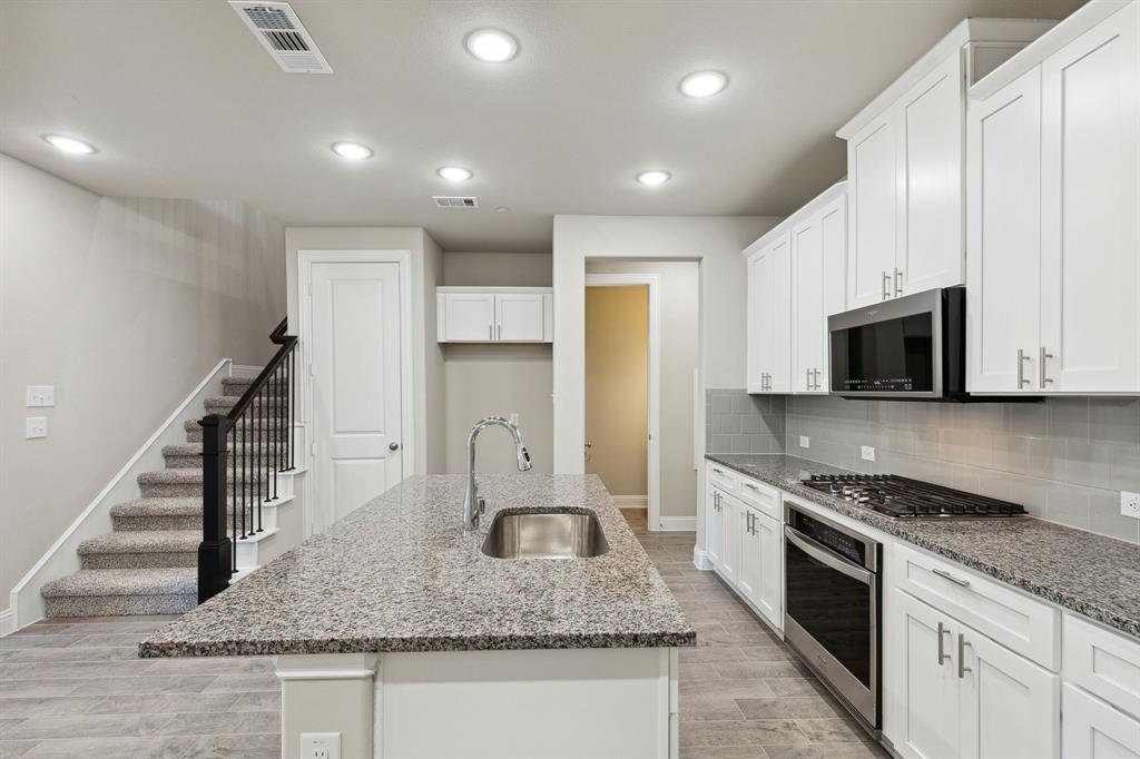 a large kitchen with stainless steel appliances granite countertop a sink and a stove