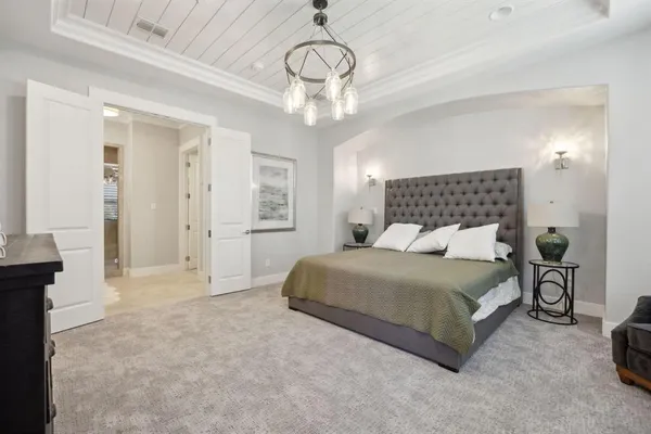 a bedroom with a large bed and a chandelier