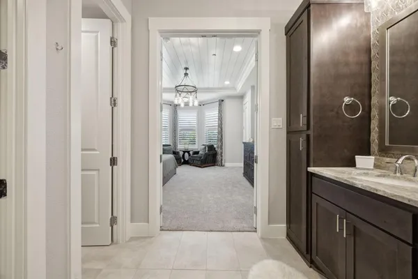 a en suite bathroom with a granite countertop sink a mirror and shower