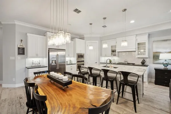 a large kitchen with a table and chairs