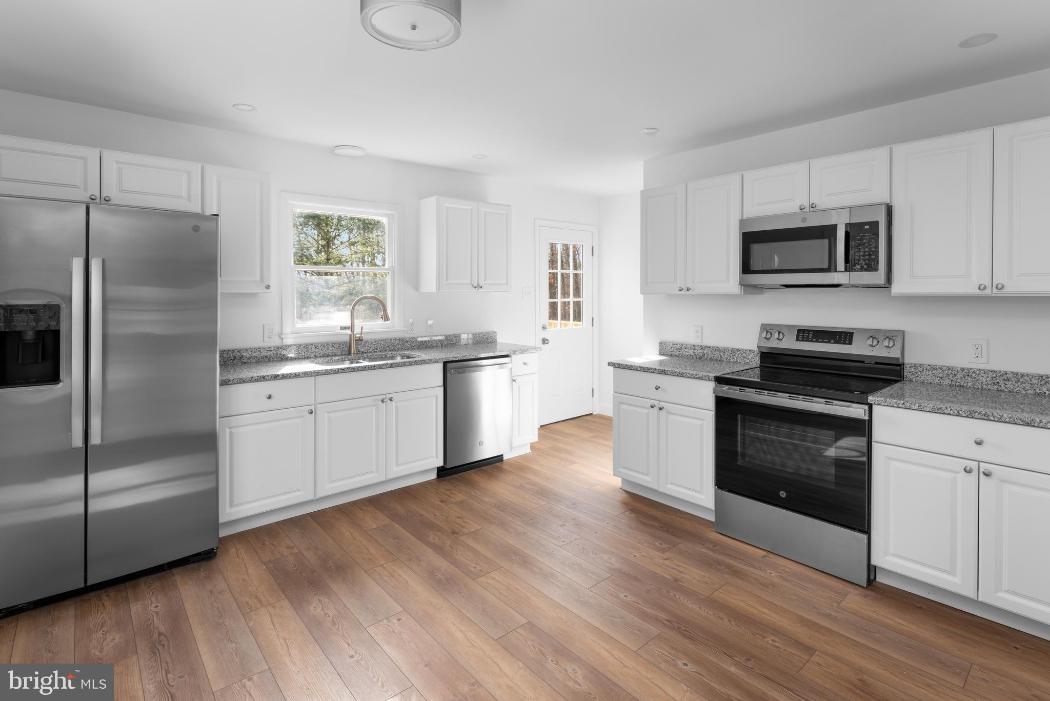 351 Ridgeview Road Gore, VA 22637 - Photo 14 of 31 a kitchen with stainless steel appliances granite countertop a refrigerator a sink dishwasher a stove and white countertops with wooden floor