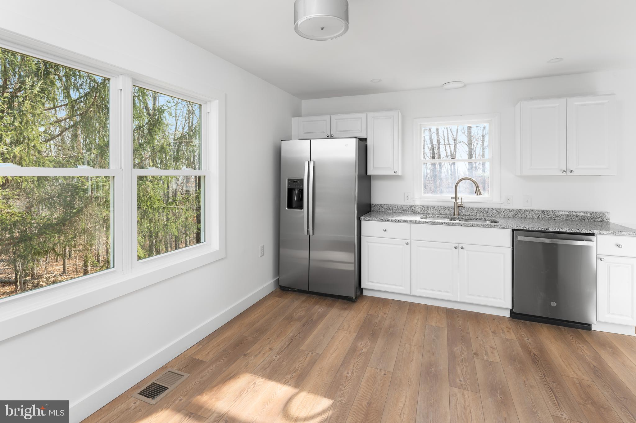351 Ridgeview Road Gore, VA 22637 - Photo 15 of 31 a kitchen with stainless steel appliances granite countertop a refrigerator a sink dishwasher a stove and white countertops with wooden floor