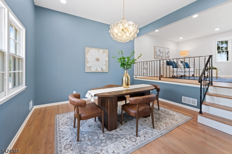 22 Hillcrest Road Hillsborough, NJ 08844 - Photo 8 of 35 a dining room with wooden floor a chandelier a wooden table and chairs
