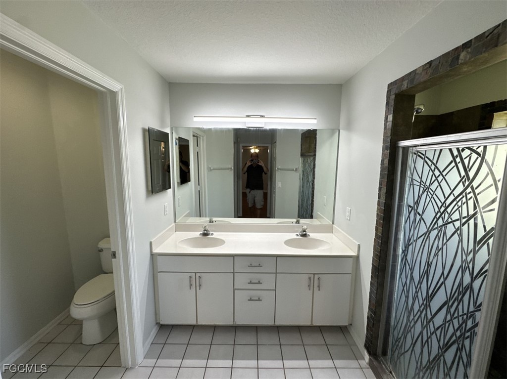 2400 Leavitt Road Alva, FL 33920 - Photo 18 of 26 a spacious bathroom with a granite countertop sink toilet and mirror
