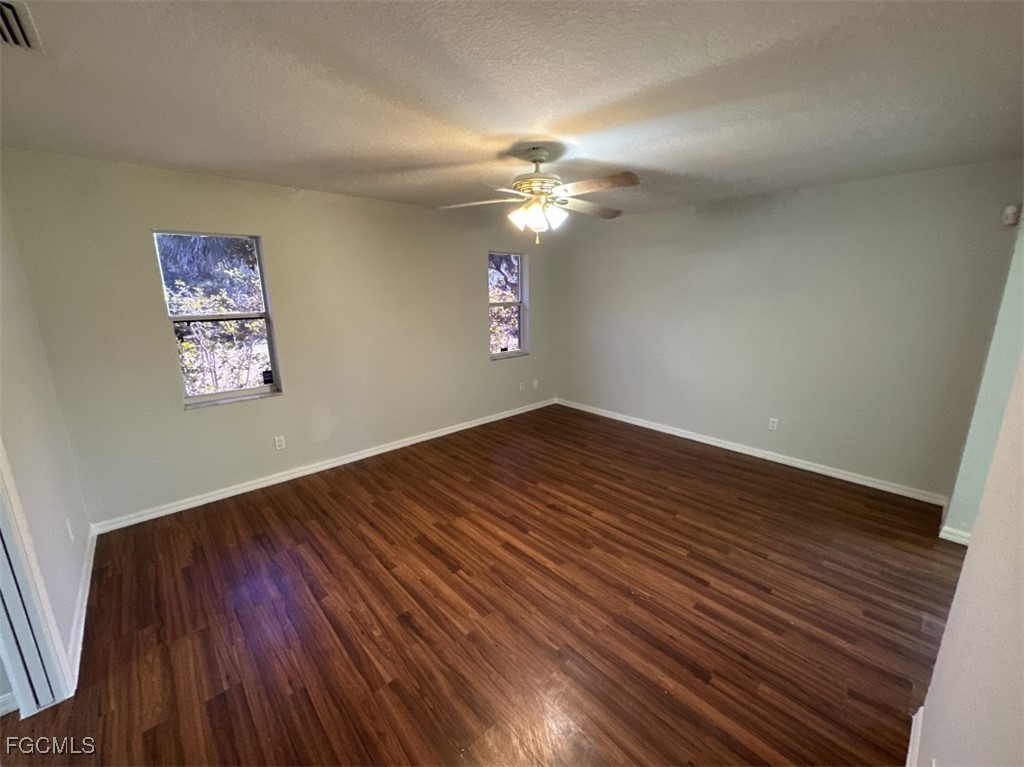 2400 Leavitt Road Alva, FL 33920 - Photo 19 of 26 a view of a hallway with wooden floor and a ceiling fan