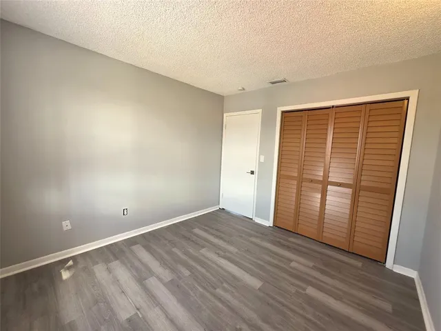 an empty room with wooden floor and sliding door