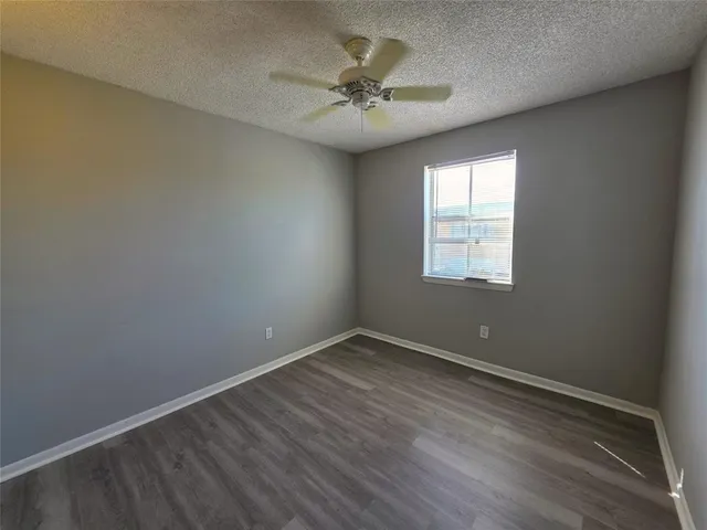 an empty room with a window and a ceiling fan