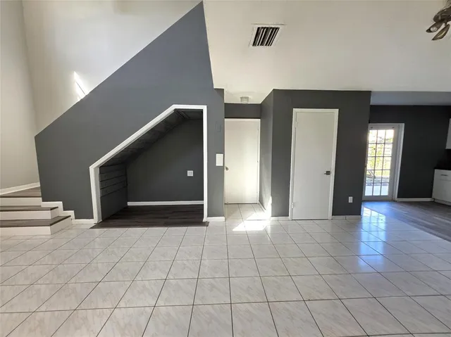 a view of a hallway with wooden floor and cabinet