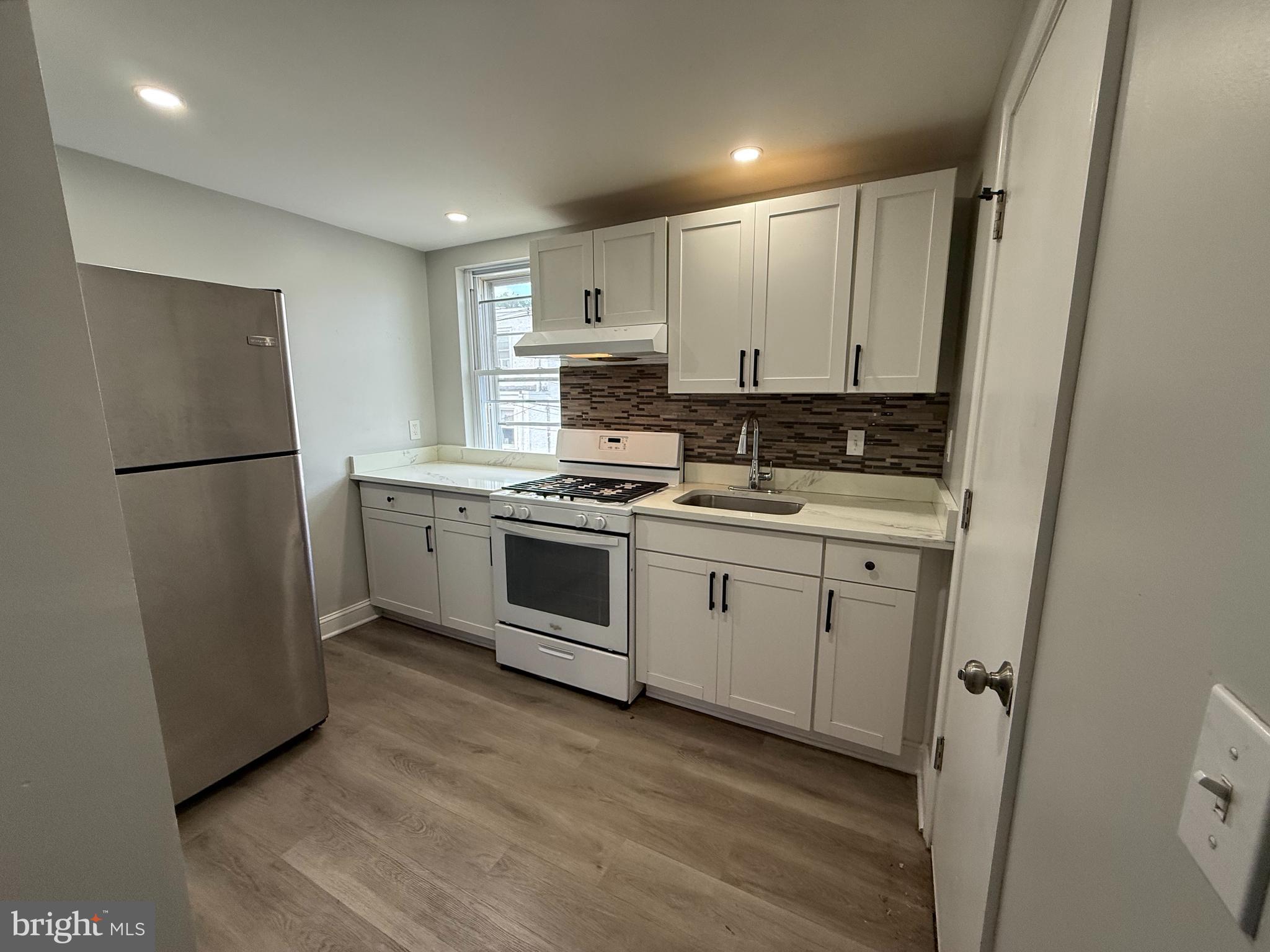 6921 Clinton Road Upper Darby, PA 19082 - Photo 2 of 17 a kitchen with white cabinets and white appliances