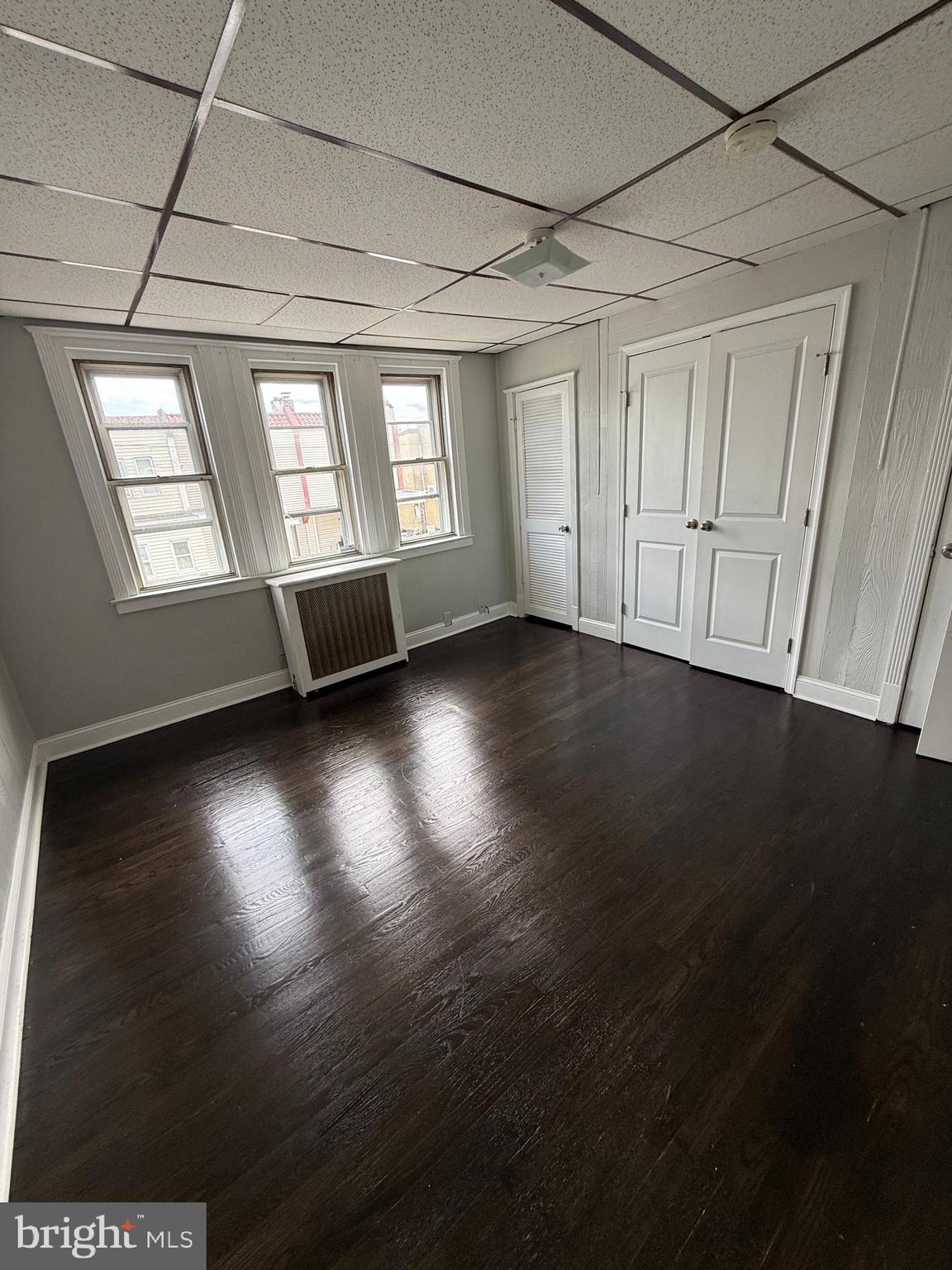 6921 Clinton Road Upper Darby, PA 19082 - Photo 9 of 17 an empty room with wooden floor and windows