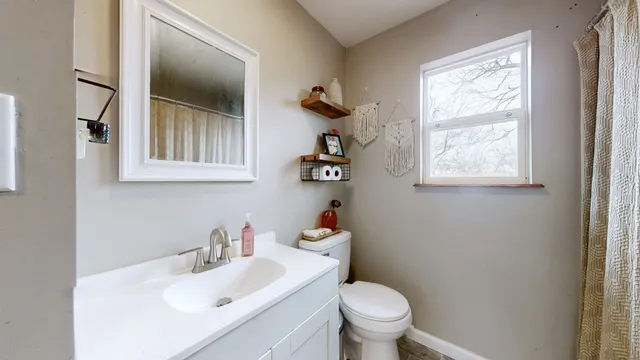 a bathroom with a sink toilet and a window