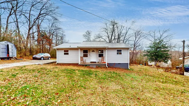 a front view of a house with a yard and trees