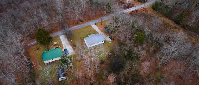 a view of a yard with plants and wooden fence