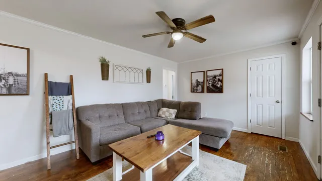 a living room with furniture and a wooden floor