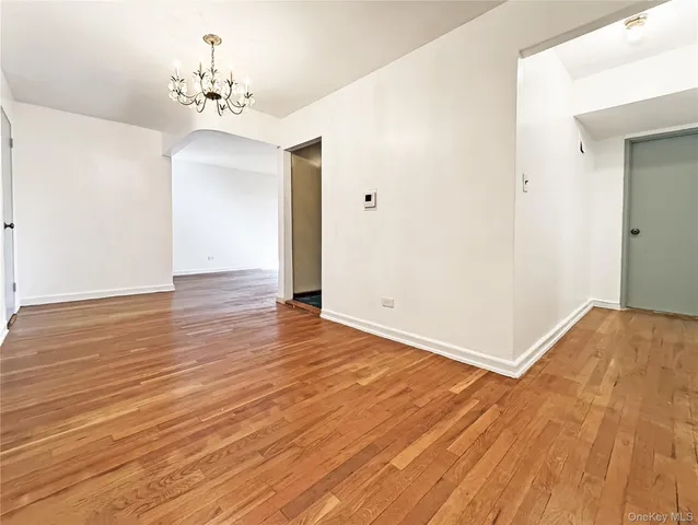 a view of a room with wooden floor and chandelier