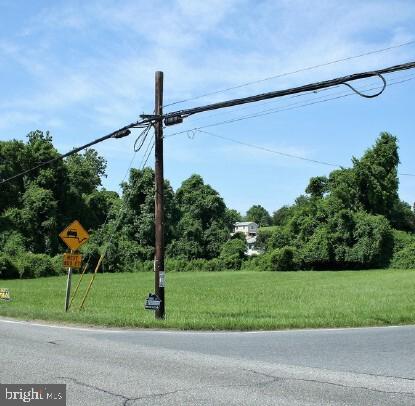 a green field with lots of trees in the background