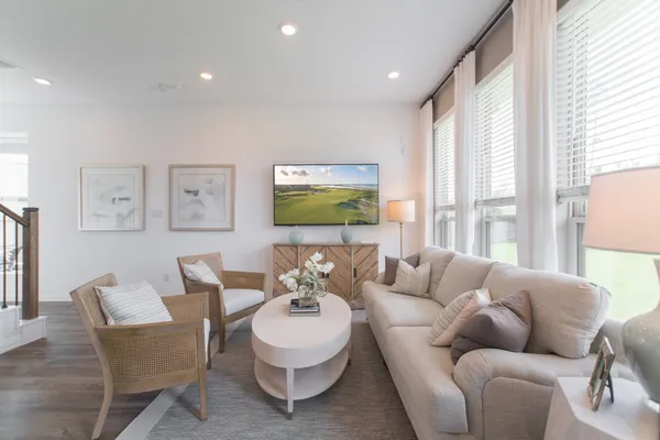 a living room with furniture a rug and kitchen view