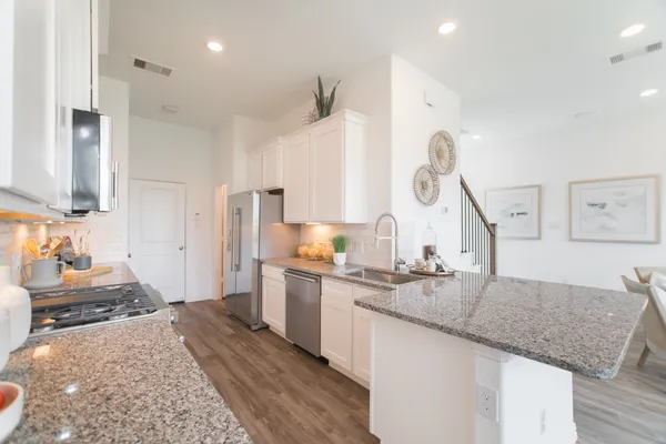 a kitchen with a sink cabinets and wooden floor