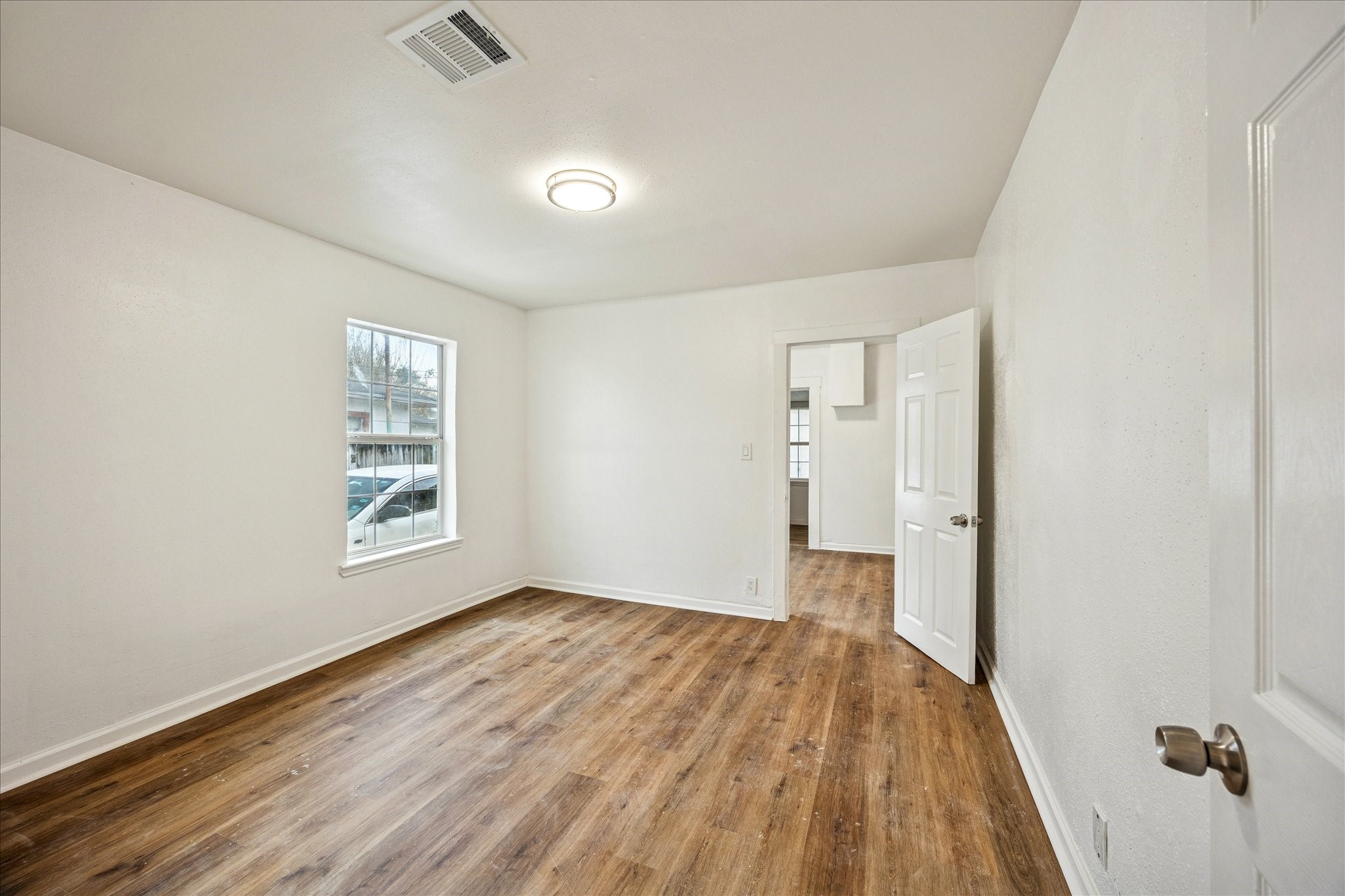 1803 Simpson Street Houston, TX 77020 - Photo 6 of 10 wooden floor in an empty room with a window