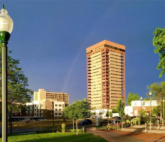 a view of a tall building in the middle of a yard