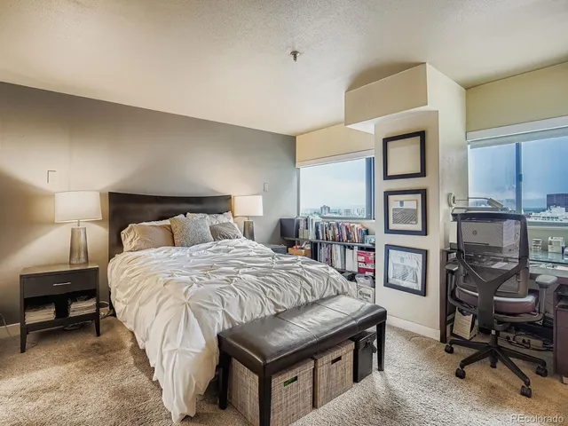 a bedroom with a bed a table and a book shelf