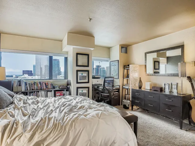 a bedroom with a bed and a dresser in it