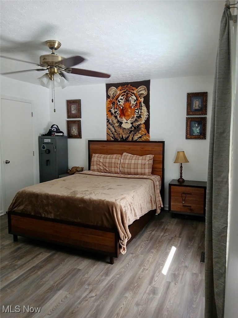 1685 Fattler Ridge Road Philo, OH 43771 - Photo 18 of 24 Bedroom featuring ceiling fan, wood finished floors, and a textured ceiling