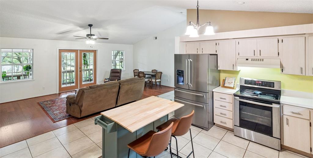 30911 Vista View Mount Dora, FL 32757 - Photo 16 of 54 a kitchen with granite countertop a refrigerator a stove a sink dishwasher a dining table and chairs with wooden floor