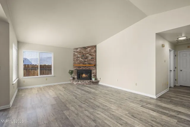 an empty room with windows and fireplace