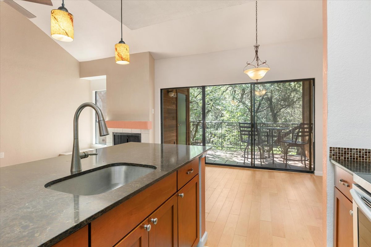 4711 Spicewood Springs Road, Unit 4222 Austin, TX 78759 - Photo 18 of 35 A well-lit kitchen boasts stone countertops and sleek hardwood flooring, opening onto a private balcony.