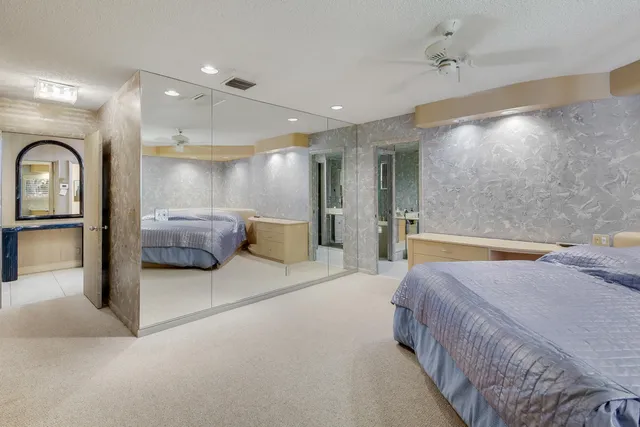 a spacious bedroom with a bed and a mirror