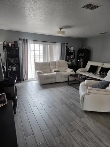a living room with furniture and wooden floor