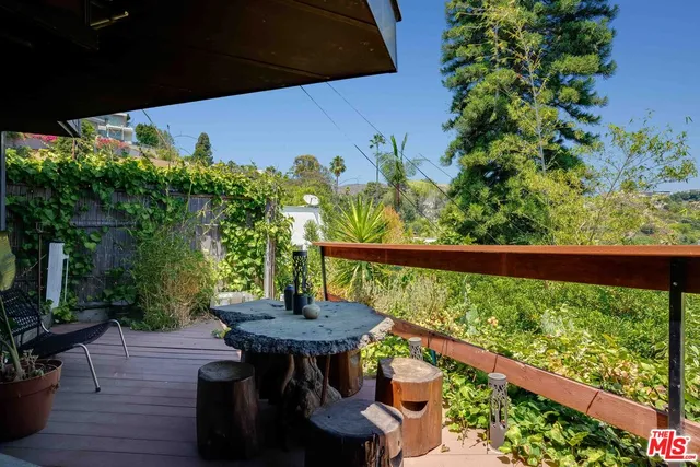 a view of a balcony with chairs and wooden floor
