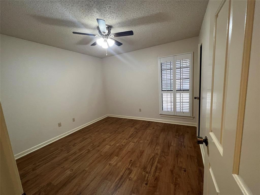 3129 Sappington Place Fort Worth, TX 76116 - Photo 9 of 15 Spare room with dark wood-style floors, a textured ceiling, and a ceiling fan