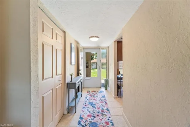 a view of a hallway with furniture and wooden floor