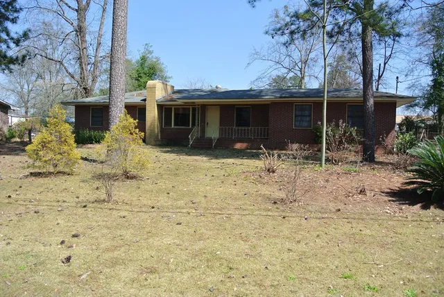 a backyard of a house with table and chairs
