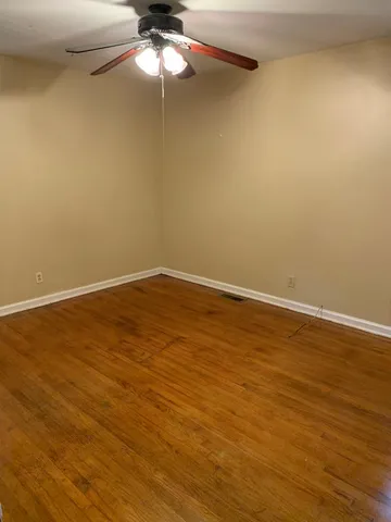 a view of a room with wooden floor and fan