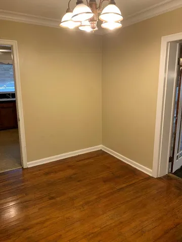 a view of a big room with wooden floor and windows in it