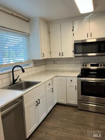 a kitchen with stainless steel appliances a sink stove and cabinets