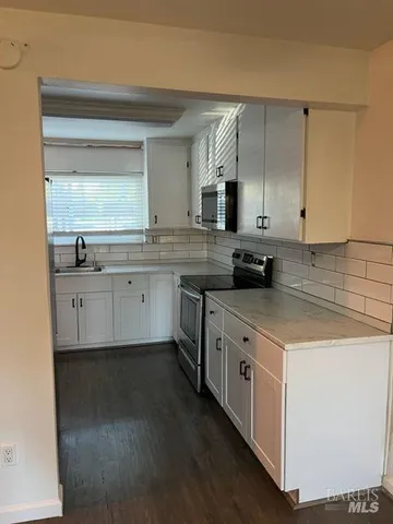 a kitchen with stainless steel appliances a refrigerator and wooden floor